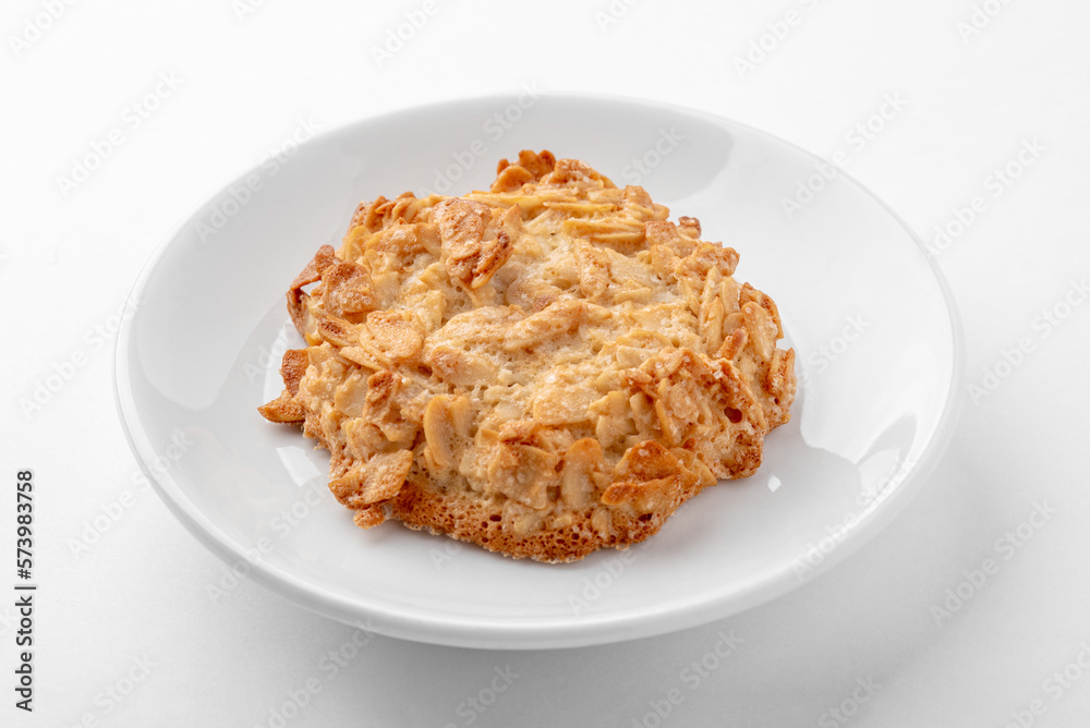 One freshly baked peanut cookie on a white plate on the table. Homemade cakes for breakfast. One freshly baked peanut cookie on a white plate on the table. Homemade cakes for breakfast.