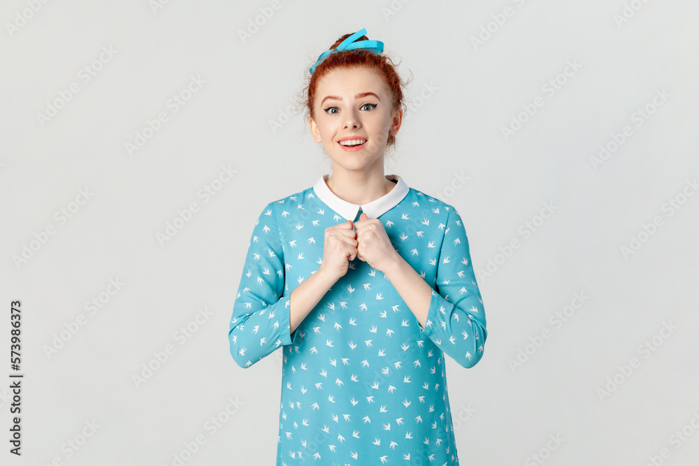 Fototapeta premium Amazed excited woman being surprised, sees something amazing, keeps hands together.