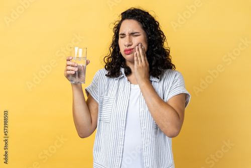 Photography Woman standing and touching his cheek because feeling pain on tooth, after drinking hot tea