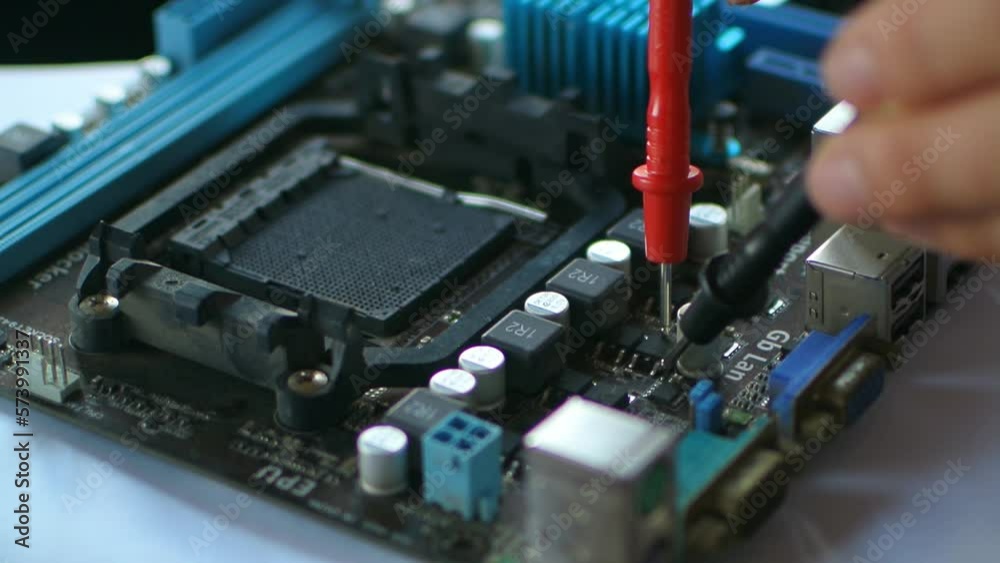 Hands fixing motherboard of pc or laptop notebook close up in service Hands fixing motherboard of pc or laptop notebook close up in service