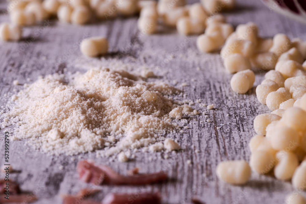 Fototapeta premium Grated Parmesan cheese and gnocchi in the background