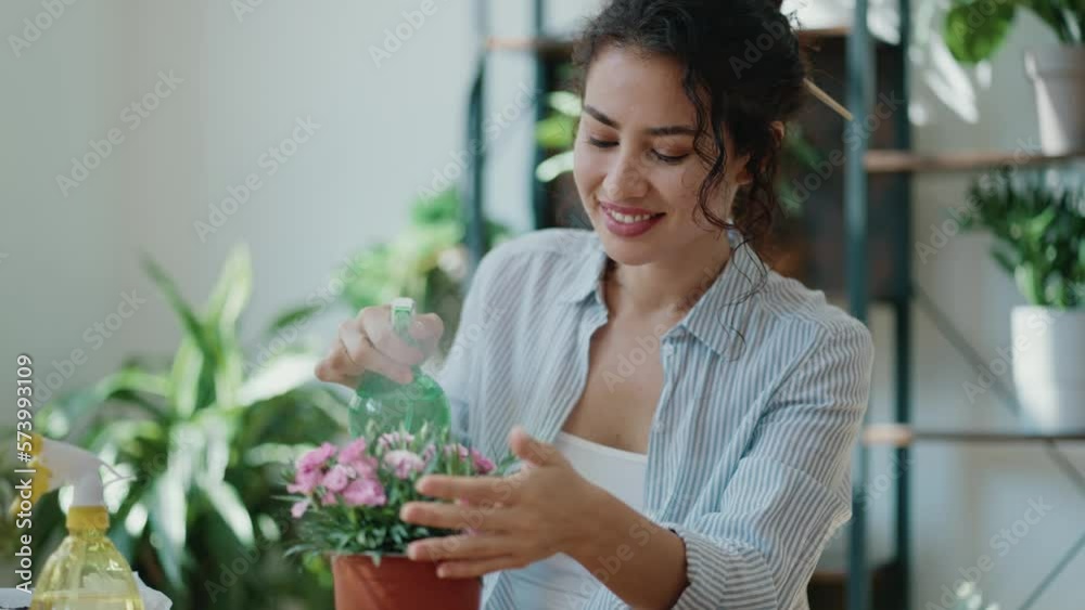 Video of beautiful smiling woman arranging plants and flowers in a greenhouse Video of beautiful smiling woman arranging plants and flowers in a greenhouse