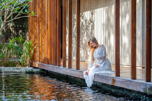 Woman relaxing at a luxury spa, barefoot on a wooden bridge photo