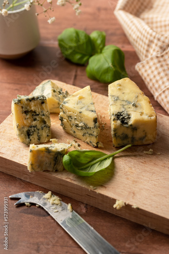 Blue cheese slices, wooden rustic background photo