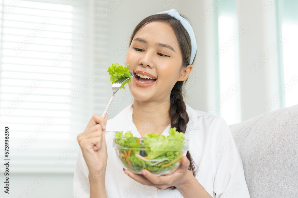 Diet, Dieting pretty attractive asian young woman, girl use fork at lettuce on mix vegetables, green salad bowl, eat food is low fat to good body. Nutritionist female, Weight loss for healthy person. Diet, Dieting pretty attractive asian young woman, girl use fork at lettuce on mix vegetables, green salad bowl, eat food is low fat to good body. Nutritionist female, Weight loss for healthy person.