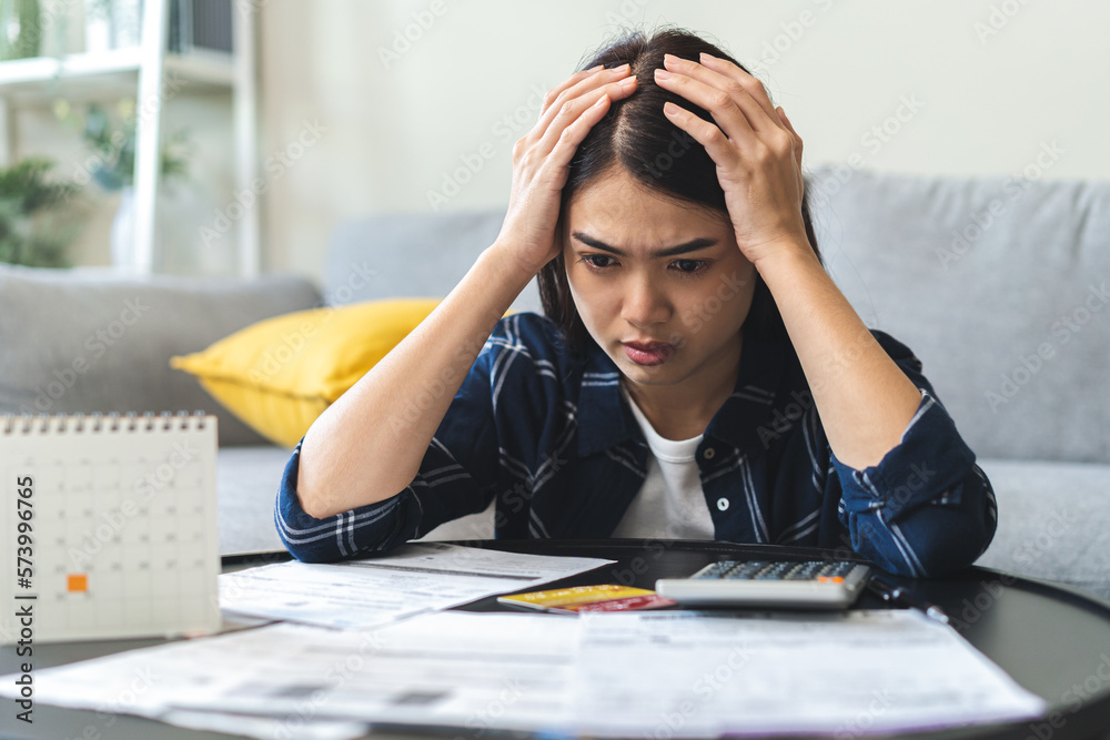 Business financial concept, owe asian young woman, female sitting expression face stressed by calculate expense on table from invoice or bill, have no money to pay mortgage or loan. Debt, bankruptcy. - obrazy, fototapety, plakaty 
