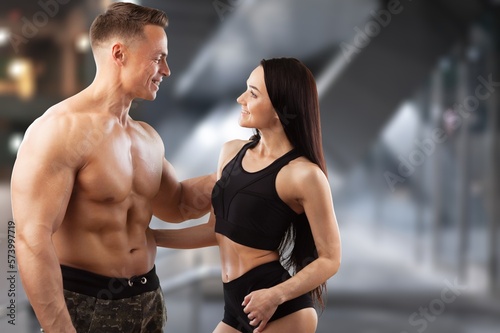Gym personal trainer with client discussing training