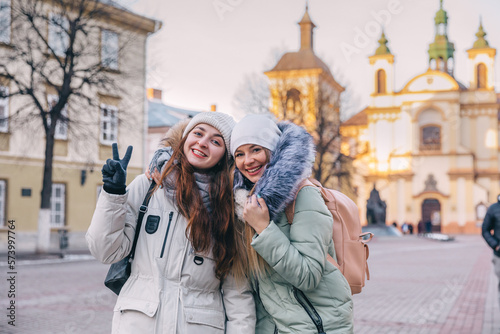 two female tourist friends travel through cities, walk the streets, pose against the background of architecture. Fun and interesting trips together