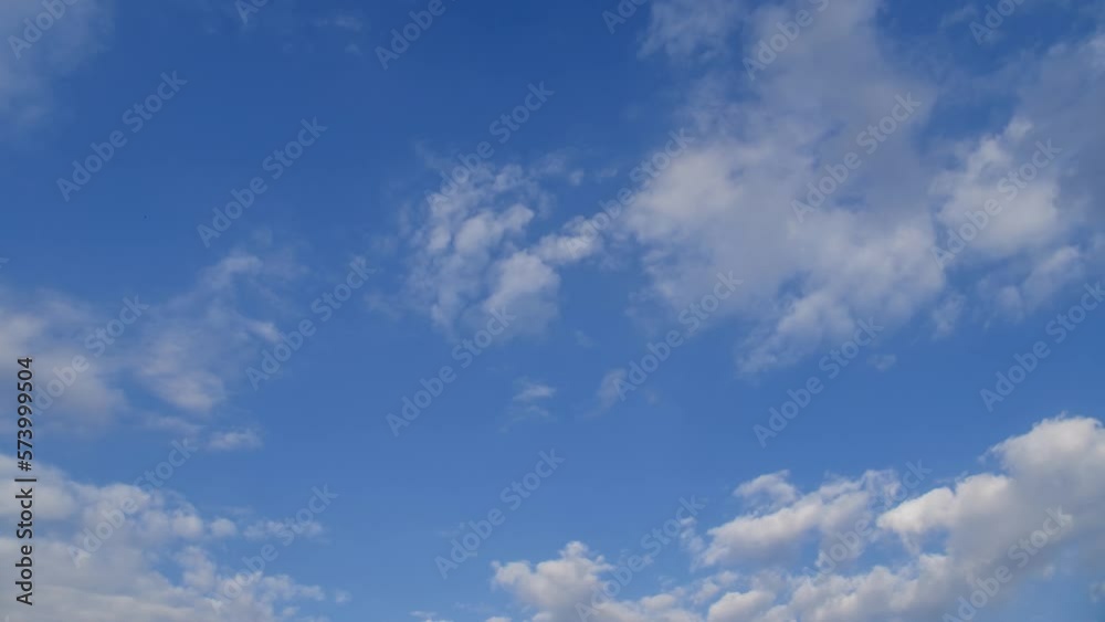 Light white clouds fly across a bright blue sky. Clear sky at sunny summer afternoon. Spring cloudscape background. Copy space Light white clouds fly across a bright blue sky. Clear sky at sunny summer afternoon. Spring cloudscape background. Copy space