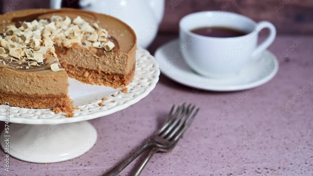 Caramel cake and tea. Cheesecake on cake stand and cup of tea. Caramel cake and tea. Cheesecake on cake stand and cup of tea.