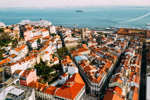 Aerial drone view of Baixa district in Lisbon, Portugal with surrounding major landmarks including Se Cathedral and cruise ship terminal on the Tagus