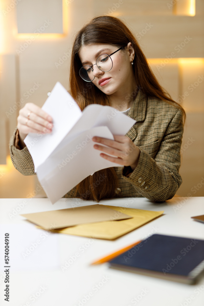 Obraz premium Business woman looks at bills and mail in the office at the table.