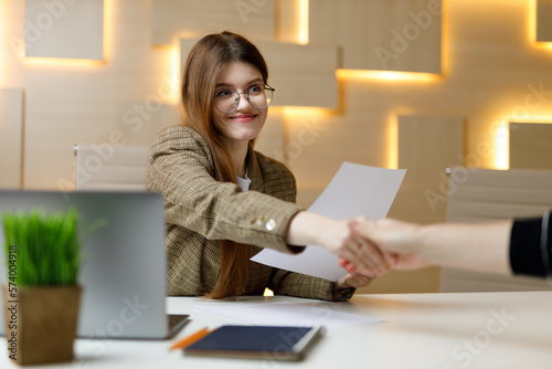 Shake hands at a job interview. Business woman in a suit hires new employees. Cooperation and welcome.