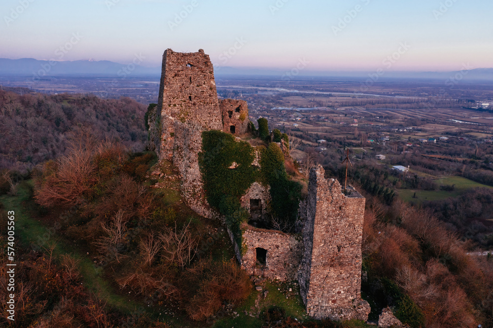Ancient old fortress. Shkhepi Castle ruin in mountains at the sunset, aerial drone view