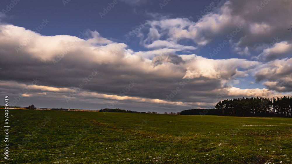 Obraz premium Billowing clouds over the fields of the polish countryside.