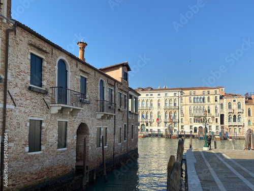 Venice, Italy - February 14, 2023: single tourist waiting water bas on pier in Venice city at sunny winter morning photo