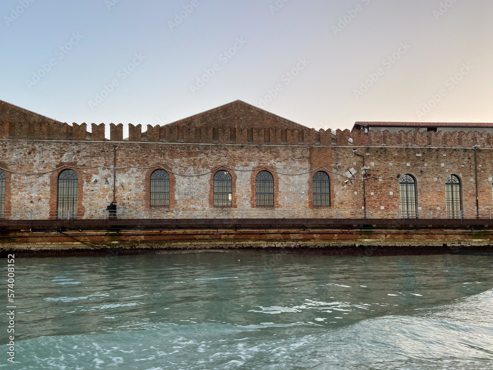 front view of facades of old stocks on waterfront in Venice city from Venetian lagoon in winter twilight