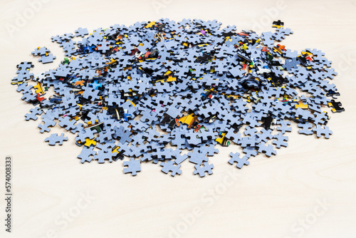 Fototapeta Naklejka Na Ścianę i Meble -  pile of blue puzzle pieces on light brown wooden table