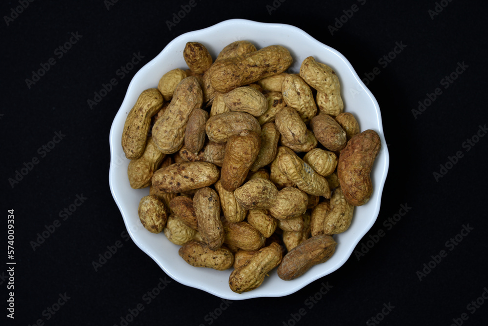 Groundnut. Unpeeled peanuts in a white plate. Peanuts in the peel. Groundnut. Unpeeled peanuts in a white plate. Peanuts in the peel.