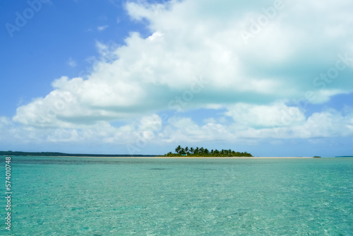 Fototapeta Naklejka Na Ścianę i Meble -  Typical tropical South Pacific scene heat haze over turquoise water, low atoll island on horizon blue sky and white clouds