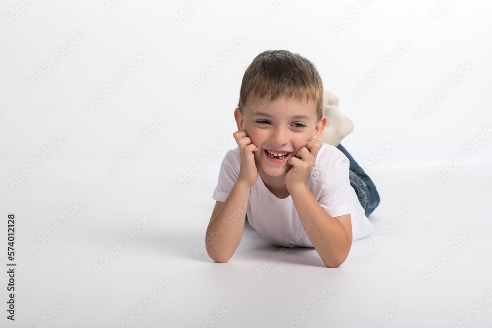 a boy of European appearance lies on a white background with a smile a boy of European appearance lies on a white background with a smile