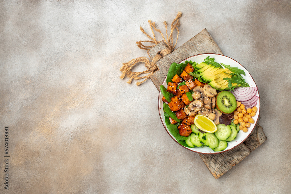 Healthy vegetarian cuisine with a tofu salad with avocado, chickpeas, cucumber and mushrooms. banner, menu, recipe place for text, top view Healthy vegetarian cuisine with a tofu salad with avocado, chickpeas, cucumber and mushrooms. banner, menu, recipe place for text, top view