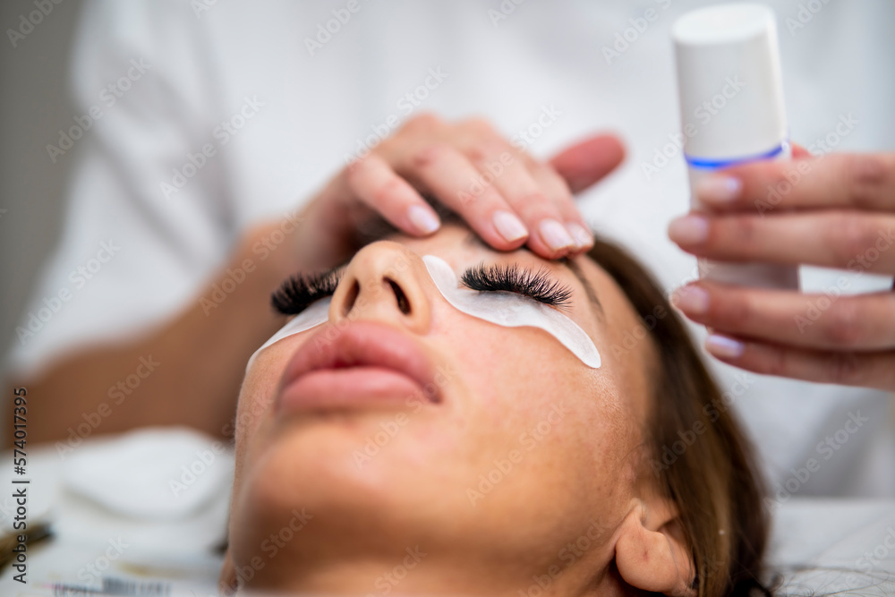 Naklejka premium Woman eye with long eyelashes. Beautiful young woman during eyebrows drawing.