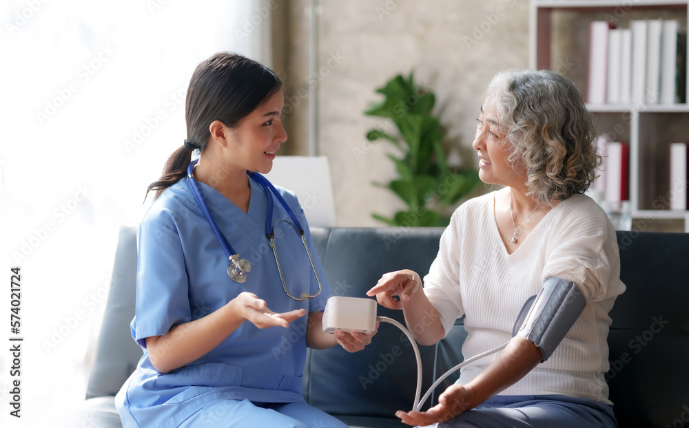Asian female doctor measuring blood pressure for an elderly female patient. Asian female doctor measuring blood pressure for an elderly female patient.