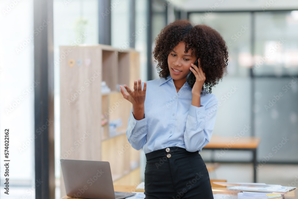 Obraz premium Businesswoman talking on the phone happily in the office.