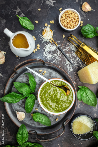 Homemade pesto sauce and ingredients, Traditional Italian pesto recipe for pasta on a dark background, vertical image. top view. place for text