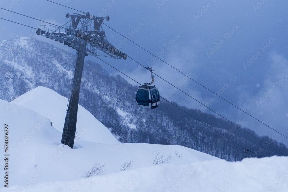 ski lift cable transporting skiers at mountain hills during snowing storm ski lift cable transporting skiers at mountain hills during snowing storm