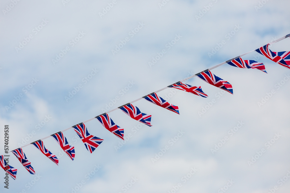 Looking up at Union Jack bunting against the sky - obrazy, fototapety, plakaty 