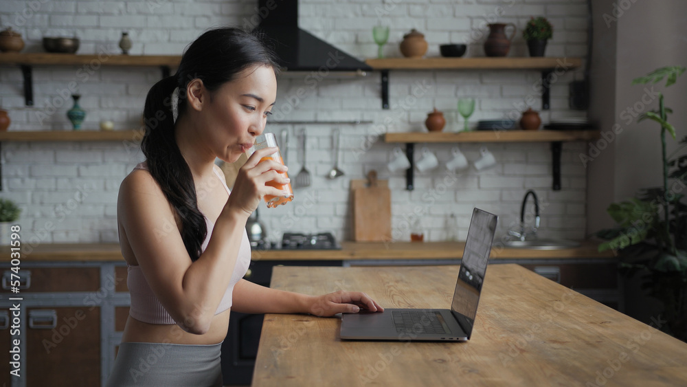 Healthy asian woman using laptop, texting message and drinking fresh juice Healthy asian woman using laptop, texting message and drinking fresh juice