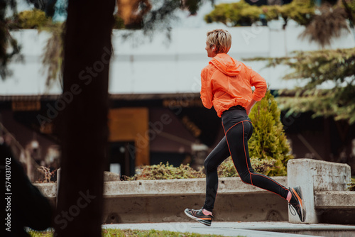  A blonde in a sports outfit is running around the city in an urban environment. The hot blonde maintains a healthy lifestyle.