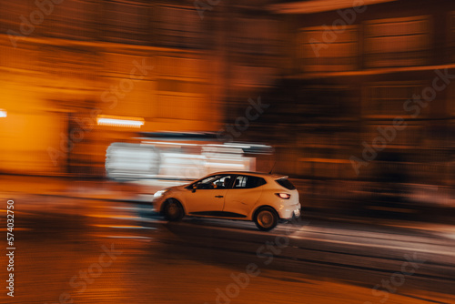 White car in motion at night, panning photo, blurry background, movement