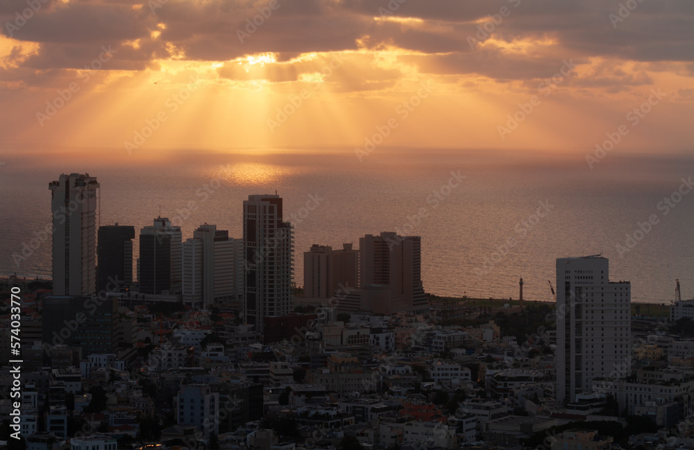 Tel Aviv orange sunset view. Sunrays on the sea, high-rise buildings