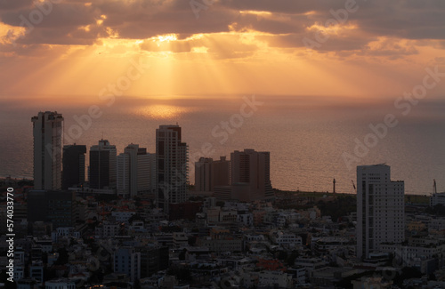 Tel Aviv orange sunset view. Sunrays on the sea  high-rise buildings