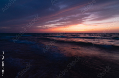 Dark Sunset over the sea shore, sandy beach, colorful sky