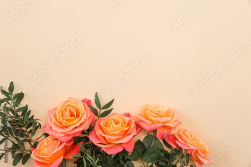 Fototapeta Naklejka Na Ścianę i Meble -  Bouquet of orange roses on beige background. Mother's day, Valentines Day, Birthday celebration concept. Greeting card. Copy space for text, top view