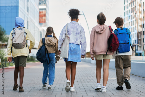 Wallpaper Mural Rear view of youthful interracial pupils of secondary school with backpacks walking down street while coming back home after lessons Torontodigital.ca