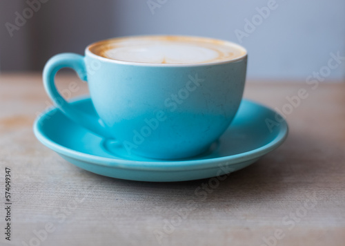 Good morning coffee. Cappuccino with latte art on wooden table. Beautiful coffee mug on a rustic table, cozy breakfast