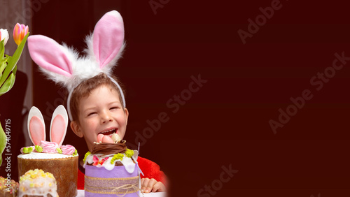 Obraz na płótnie Cute little boy with bunny ears looking at tasty easter sweet cake w salonie