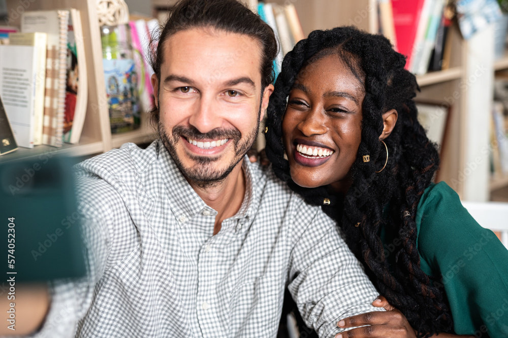 A multicultural couple taking a selfie in a library, enjoying each other's company and sharing happy moments together. The couple's different ethnicities, emphasizing the beauty of cultural diversity A multicultural couple taking a selfie in a library, enjoying each other's company and sharing happy moments together. The couple's different ethnicities, emphasizing the beauty of cultural diversity
