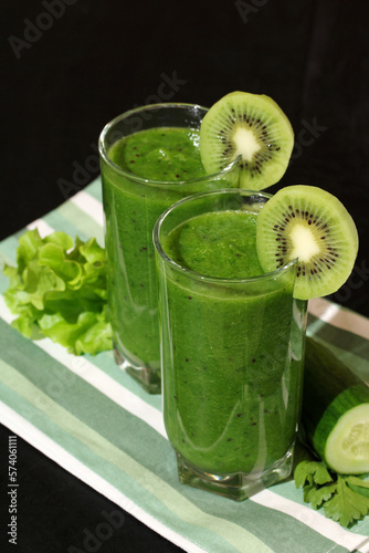 glasses of smoothies made of raw cucumbers, kiwi and lettuce leaves. green vitamin drink.