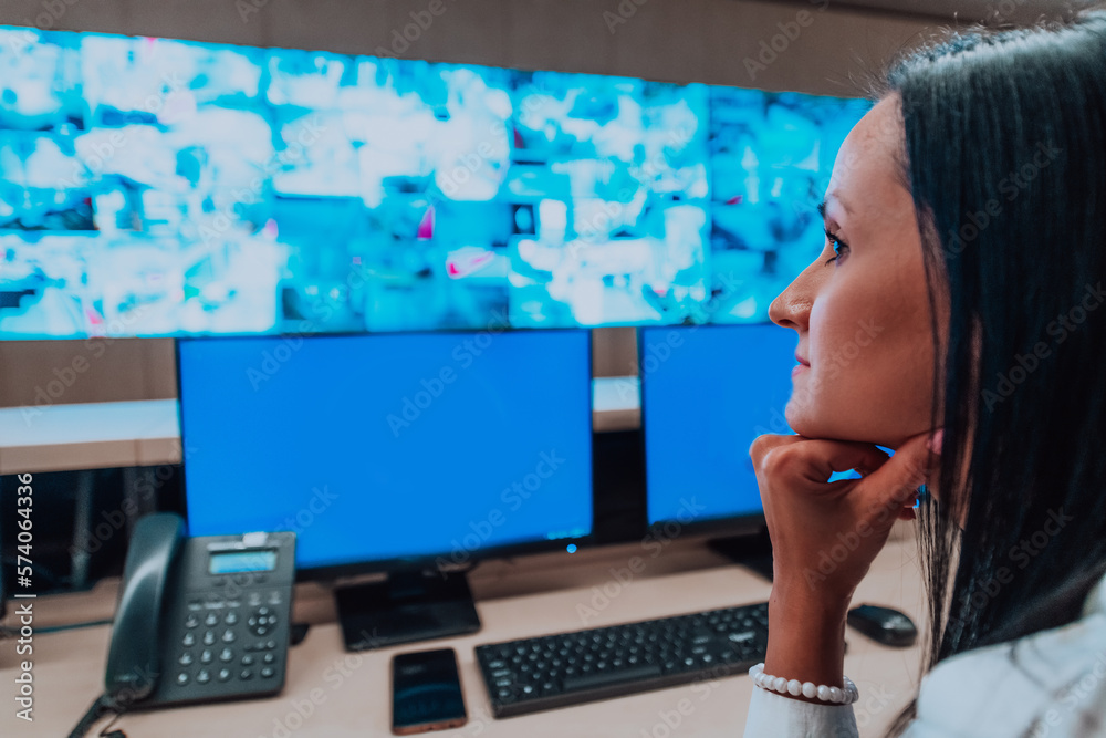 Female security operator working in a data system control room offices ...