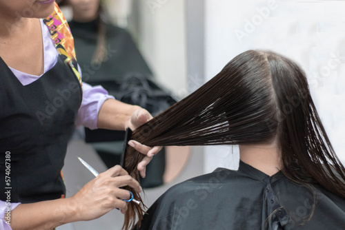 Hairdresser cutting a girl's hair.