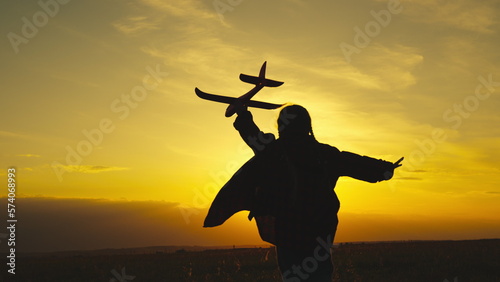 child pilot airplane runs sunset. silhouette child pilot airplane. chidhood dream. happy family. kid child runs rays sunlight. little superhero child. silhouette kid runs with a toy plane in his hand