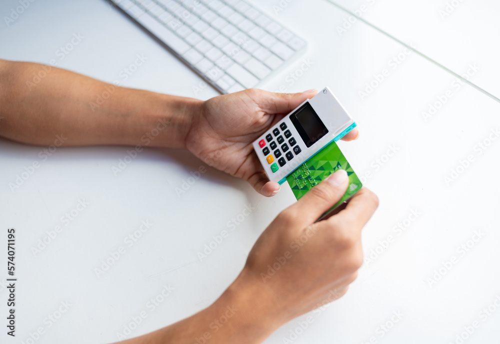 Person charging with Mpos to client's credit card at desk. Person charging with Mpos to client's credit card at desk.