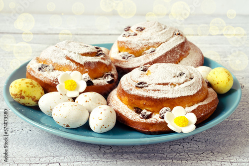 Delicious fresh pastries with icing sugar on a blue plate with chocolate sweet eggs for Easter gift © Kateryna Kutsevol