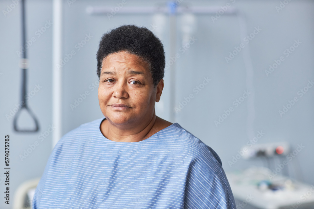 Minimal portrait of black senior woman looking at camera in hospital room, copy space